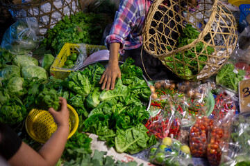 Green vegetables, chilli, and lemons in a rural market. A variety of garden vegetables in a morning market in a country where agriculture is abundant.