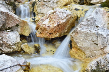 Tranquil Stream Flowing Over Colorful Rocks in Nature