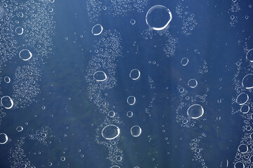 underwater background at depth, air bubbles in the water, aquarium texture of dark water