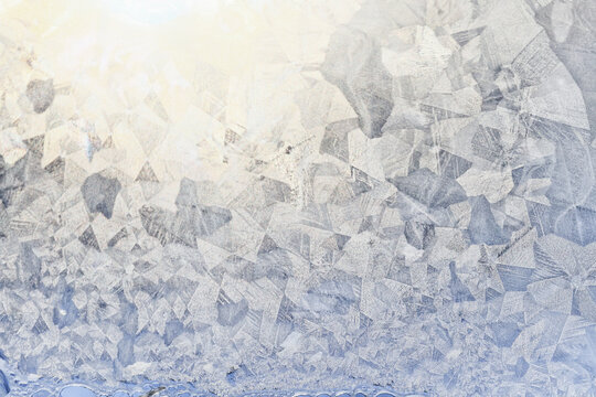 white winter background, frosty patterns on glass, abstract backdrop of ice and snow crystals in a blur