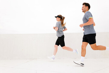 Energetic joggers enjoy a sunny day at a minimalist outdoor running track, emphasizing health and...