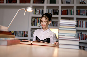 A girl in the library with a book.