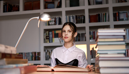 A girl in the library with a book.