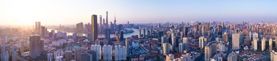 Aerial view of Shanghai skyline with winding river at sunrise.