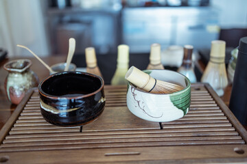 Traditional Japanese tea bowl with bamboo whisk on wooden tray for tea ceremony preparation
