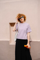 Joyful woman stretching arms up in lavender t-shirt