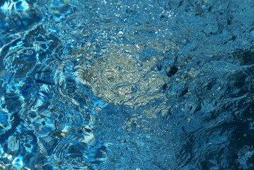 Blue transparent sea surface with bubbles water background