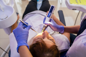 Woman is getting dental treatment in a dentist clinic