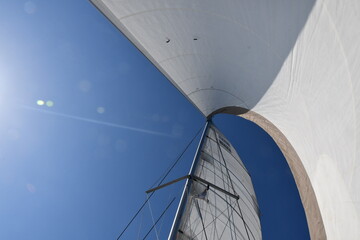 Majestic Sail Against a Bright Blue Sky: A Dynamic Perspective of Sailing Adventures