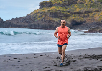 Man running on the black sand beach