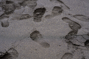 Footprints on black volcanic sand