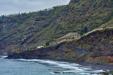 Terraced plantations above volcanic beach