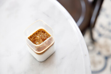 Cup of milk dirty coffee on white marble table by the window.