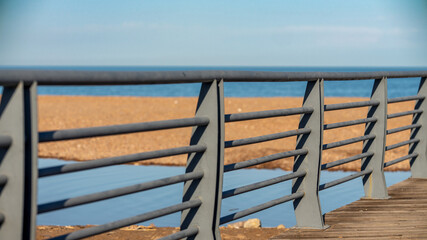 Seaside metal railing with beach and sea view