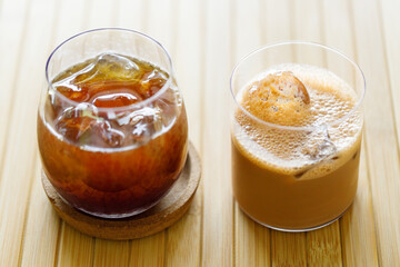 glasses of iced black coffee and milk latte coffee on table by the window.