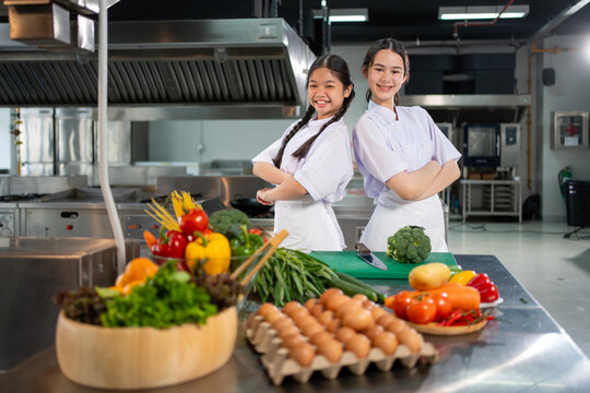 Culinary school student is posing inside the kitchen with fresh ingredient for cooking class school and education concept