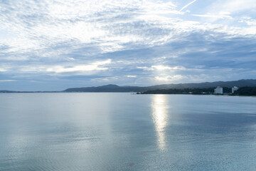 曇り空の名護浦湾海岸の日の出