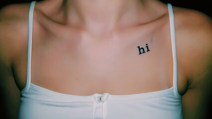Minimalist Tattoo: 'Hi' on a Woman's Shoulder