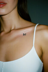 Minimalist Tattoo: 'Hi' on a Woman's Shoulder