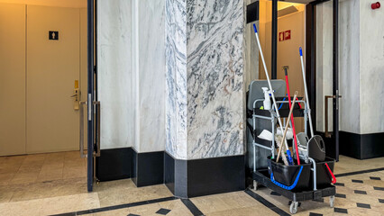 A janitor's cart waits in a marble-clad hallway, whispering tales of spring cleaning and Labor Day diligence