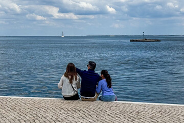 Graced by ocean zephyrs, diverse trioCaucasian man, two womenbasks in maritime serenity, ideal for...