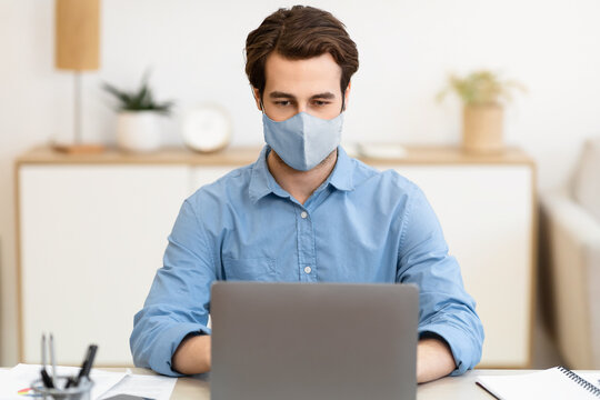 Businessman Wearing Face Mask Working On Laptop Computer Online Sitting At Workplace In Modern Office. Remote Work, Business And Entrepreneurship During Coronavirus Pandemic Concept - Powered by Adobe