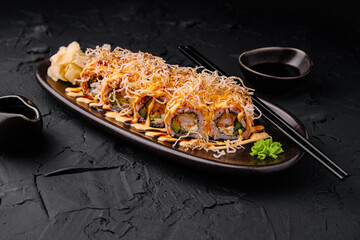 Delicious sushi rolls served on a dark plate with garnishes