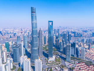 Aerial view of Shanghai skyscrapers in downtown with winding river on sunny day.