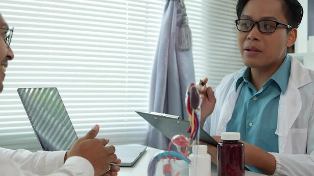 A male patient with a urinary tract infection visits a doctor at a hospital examination table to discuss his symptoms. Talk about an enlarged prostate.