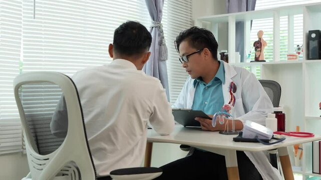 A male patient with a urinary tract infection visits a doctor at a hospital examination table to discuss his symptoms. Talk about an enlarged prostate.