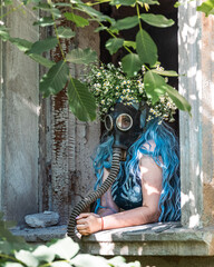 Woman in gas mask at destroyed building