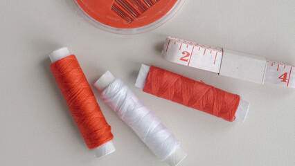 Flat lay of sewing tools including threads, pins and measure tape for DIY