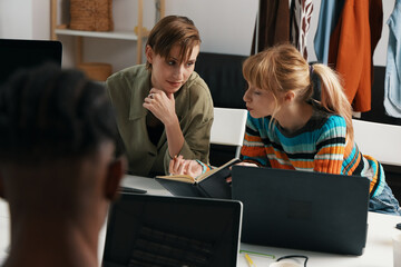 Young adult woman colleagues working together on business tasks in modern workplace, socializing...