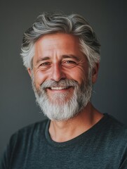 Obraz premium Happy middle-aged man with gray hair, beard and mustache in casual shirt against neutral background