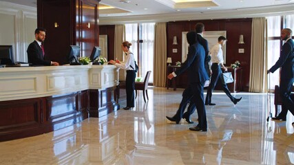 Airline crew members walking through luxurious hotel lobby after checking in, professional team interacting confidently while carrying luggage