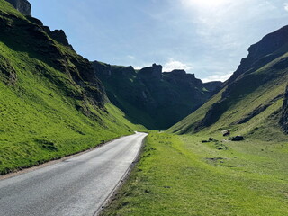 Panorama of scenic road winding through Winnats Pass in the Peak District, England, UK.