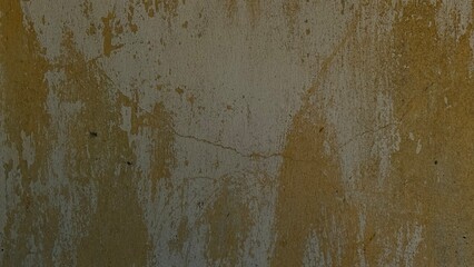 A close view of a grungy, weathered yellow wall with stains, cracks, and textures from age and moisture.
