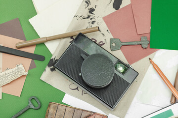 Flat lay with vintage camera, cassette, notebook, key and research tools on green background