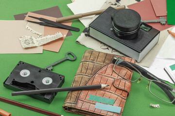 Flat lay with vintage camera, cassette, notebook, key and research tools on green background