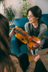 Music Teacher Teaching Student How To Hold Violin