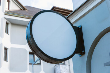 Blank circular signage on exterior wall, ready for custom logo, storefront branding or commercial...