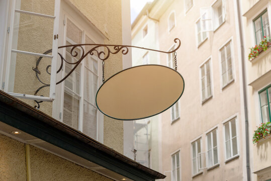 Retro style empty signage board with wrought iron support, ideal for traditional business mockups, bakery or local artisan shop branding.