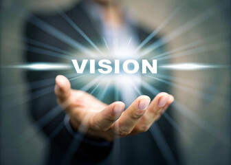 Hand holding floating vision text in futuristic style business concept glowing light innovation leadership inspiration motivation success hope and ambition in modern workplace