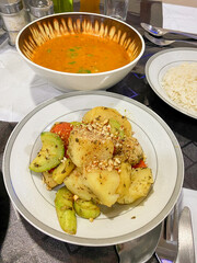 High angle shot of Paraguayan cuisine served in hotel. Delicious local food of sopa de verduras (vegetable soup), panache de verduras (mixed vegetable dish) on dining table. Vertical shot