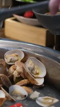 Close Up Cooking Stir Fried Quahaug Shell with Garlic with Ladle and Hot Frying Pan