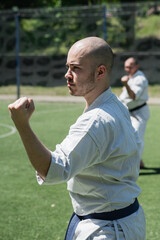 Man practicing karate in traditional uniform outdoors.