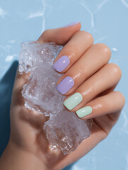 Close-Up of Pastel Summer Manicure Holding Ice Against Blue Background