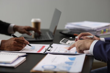 Businessman is calculating profit and analyzing financial data on report in office. Advisor is...