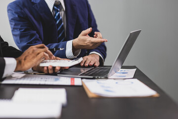 Businessman is calculating profit and analyzing financial data on report in office. Advisor is...