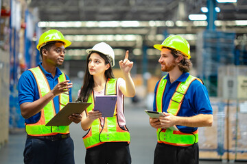 Confident warehouse team leader pointing and analyzing logistics strategy. Collaboration, leadership, digital technology, and safety protocols in supply chain.